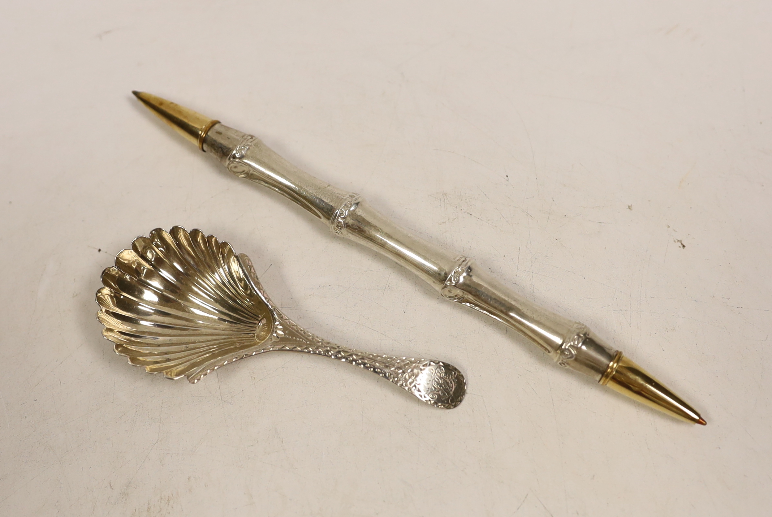 A George III silver bright cut engraved caddy spoon, Walter Brind, London 1785, 91mm, a pair of Georgian silver sugar tongs and two pens.